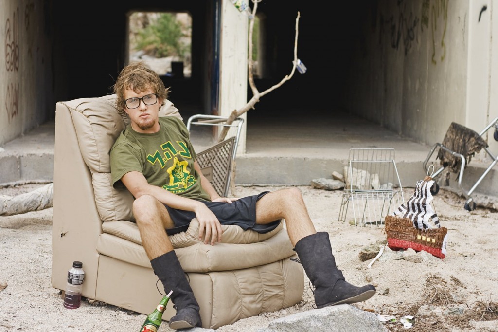 Man sitting in a scrap yard, illustrating spam and financial websites